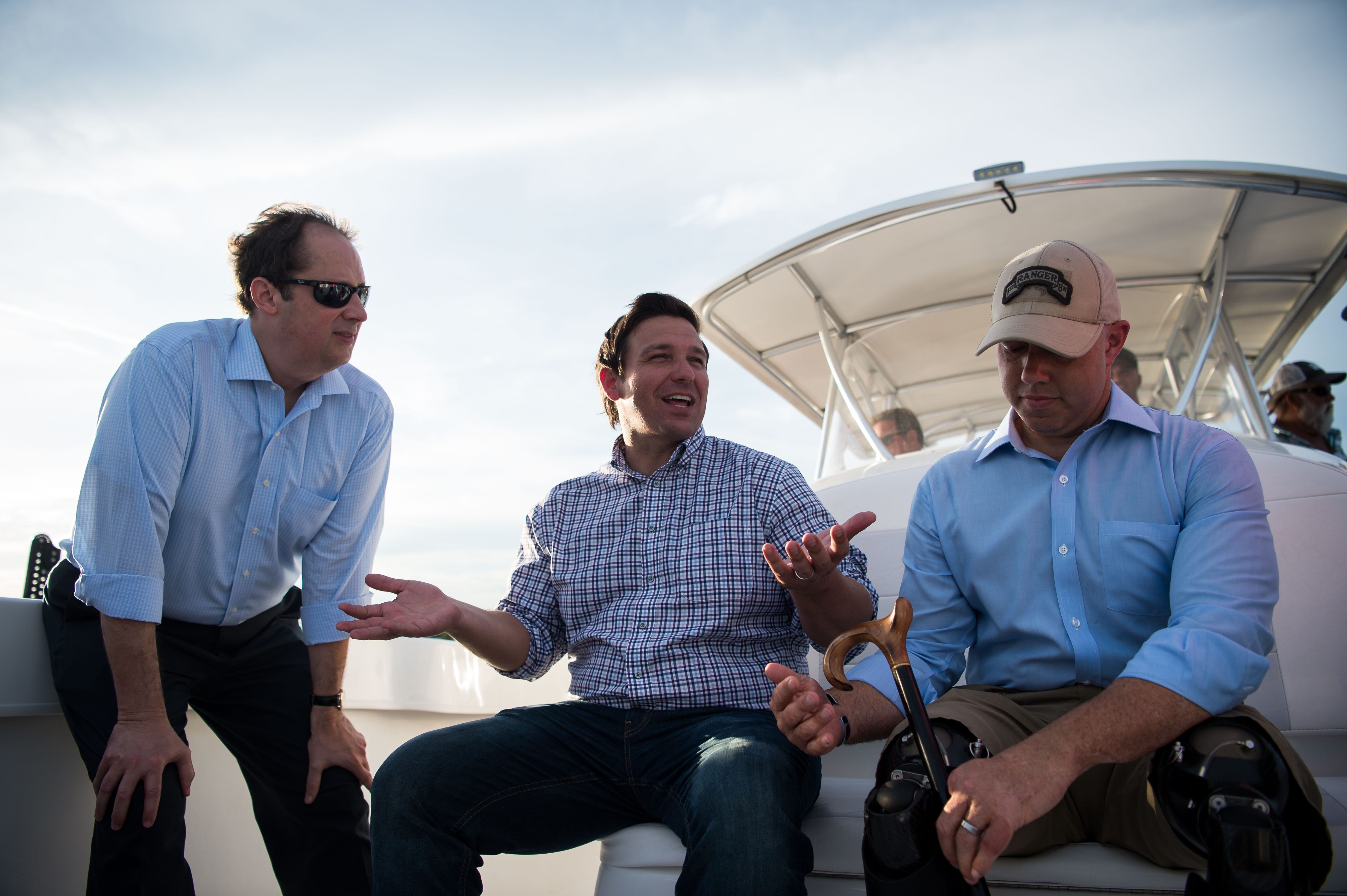 U.S. Reps. Ron DeSantis and Brian Mast take a boat ride out of Stuart, accompanied by Florida Sen. Joe Negron and other stakeholders, on Monday, Aug. 20, 2018, to see and discuss the algae crisis in the St. Lucie River.