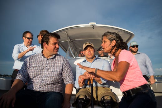 U.S. Reps. Ron DeSantis (left) and Brian Mast (center) speak with environmental advocate Jacqui Thurlow-Lippisch on Monday, Aug. 20, 2018, during a boat tour to see and discuss the algae crisis in the St. Lucie River.