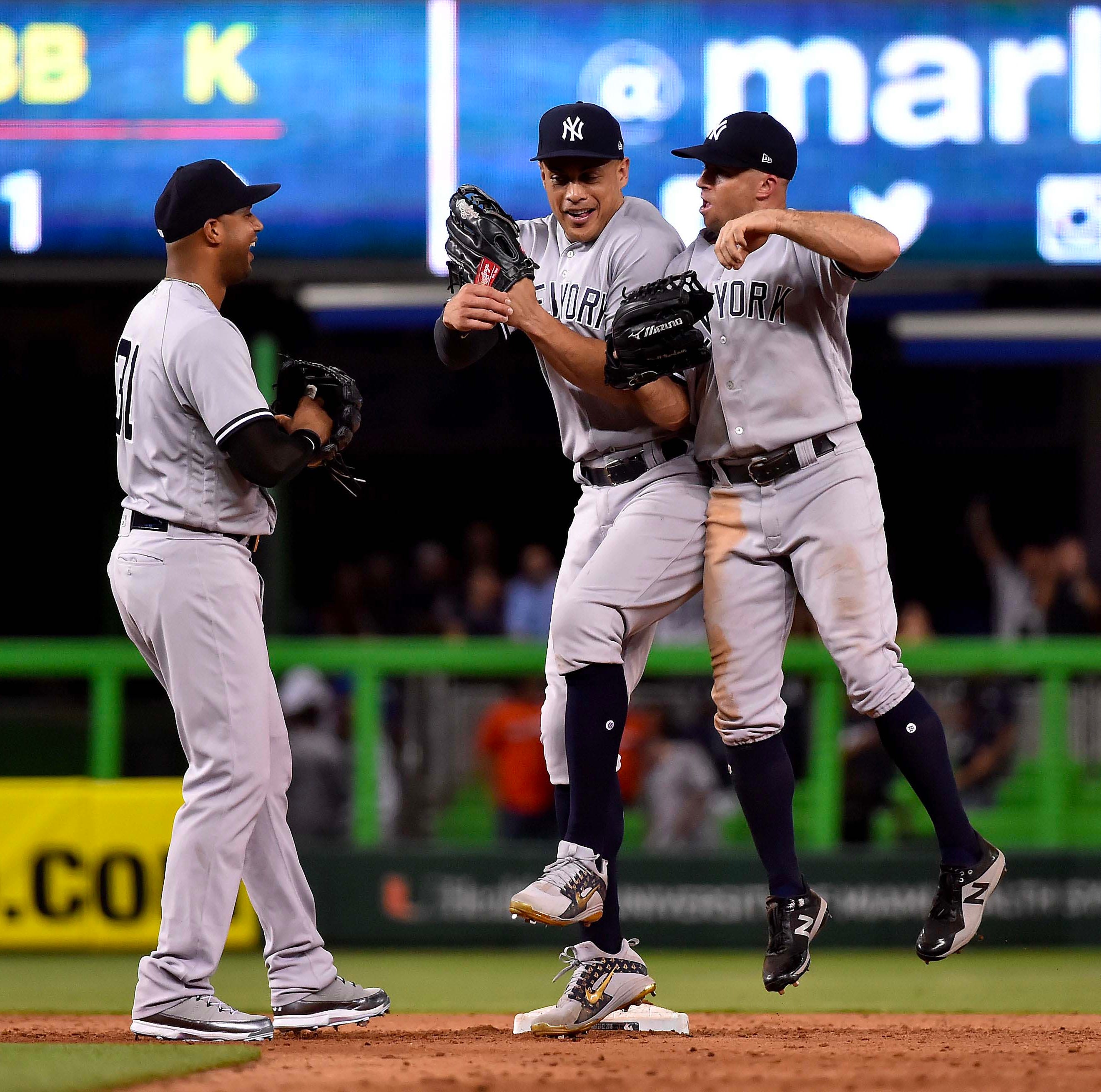 Aaron Hicks, Giancarlo Stanton and Brett Gardner celebrate the Yankees' win in Miami on Tuesday.
