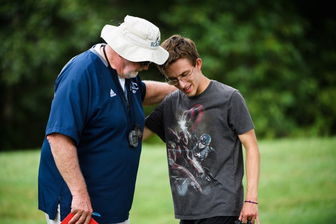 Louden Craig, 17, speaks with his cross country coach David Smith during practice at Greer Middle College Charter High School on Wednesday, Aug. 22, 2018.