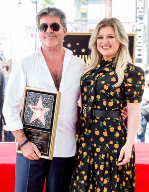 Simon Cowell (L) and Kelly Clarkson attend a ceremony honoring Cowell with a star on the Hollywood Walk of Fame on August 22, 2018.