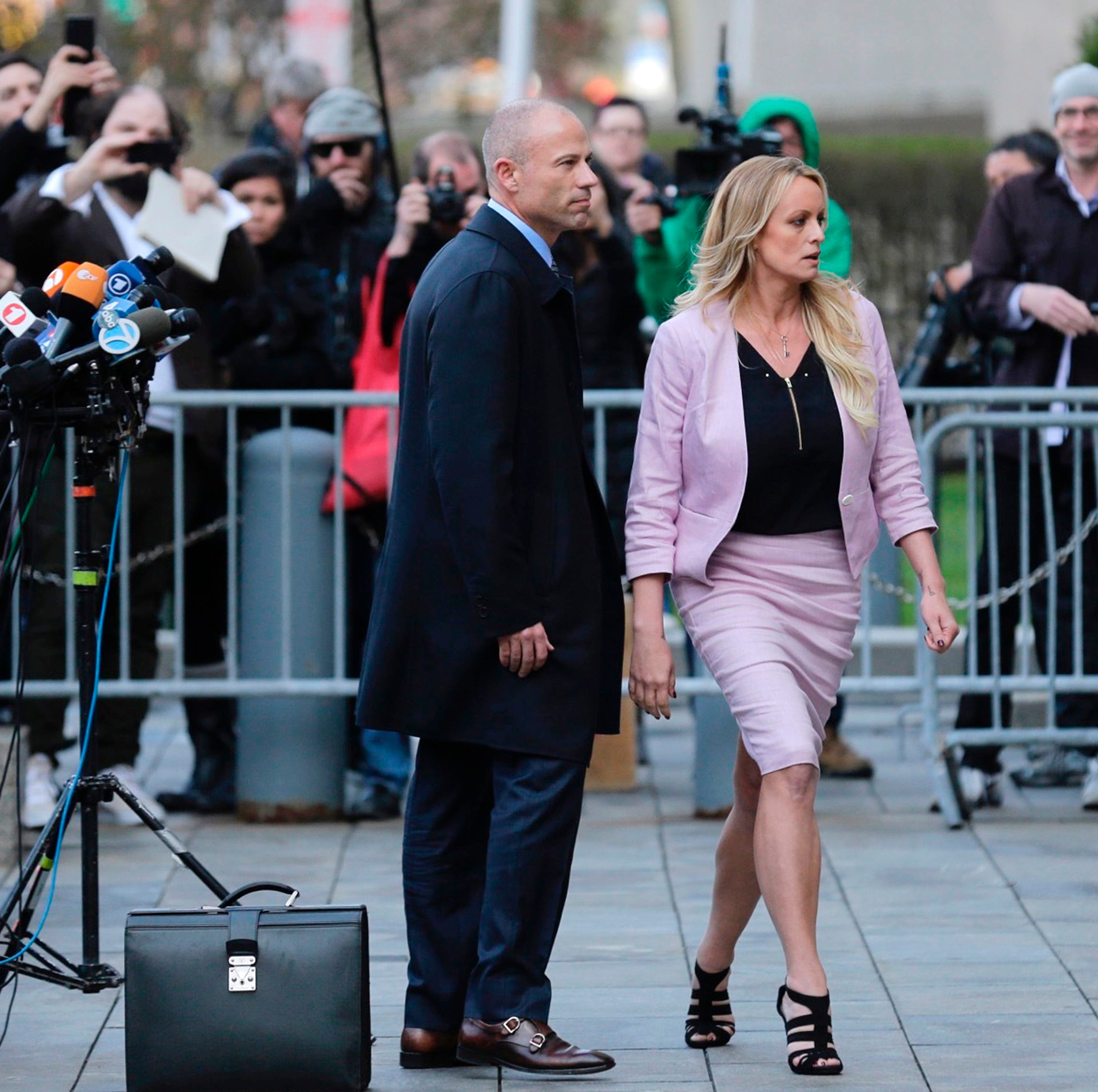 Porn actress Stormy Daniels, accompanied by her attorney, Michael Avenatti, left, leaves federal court, Monday, April 16, 2018 in New York. A U.S. judge listened to more arguments about President Donald Trump's extraordinary request that he be allowe