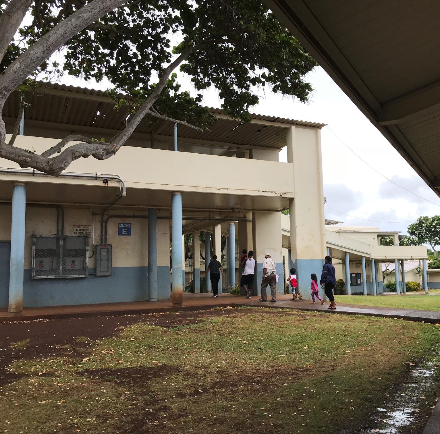 A family checks in at the Dole Middle School in Honolulu to escape possible harm from Hurricane Lane.