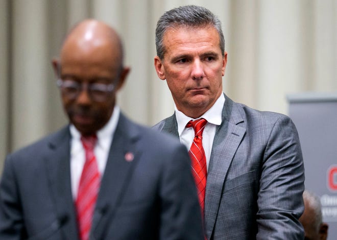 Ohio State football coach Urban Meyer follows school president Michael Drake into Wednesday's press conference announcing that Meyer would be suspended for the first three games.