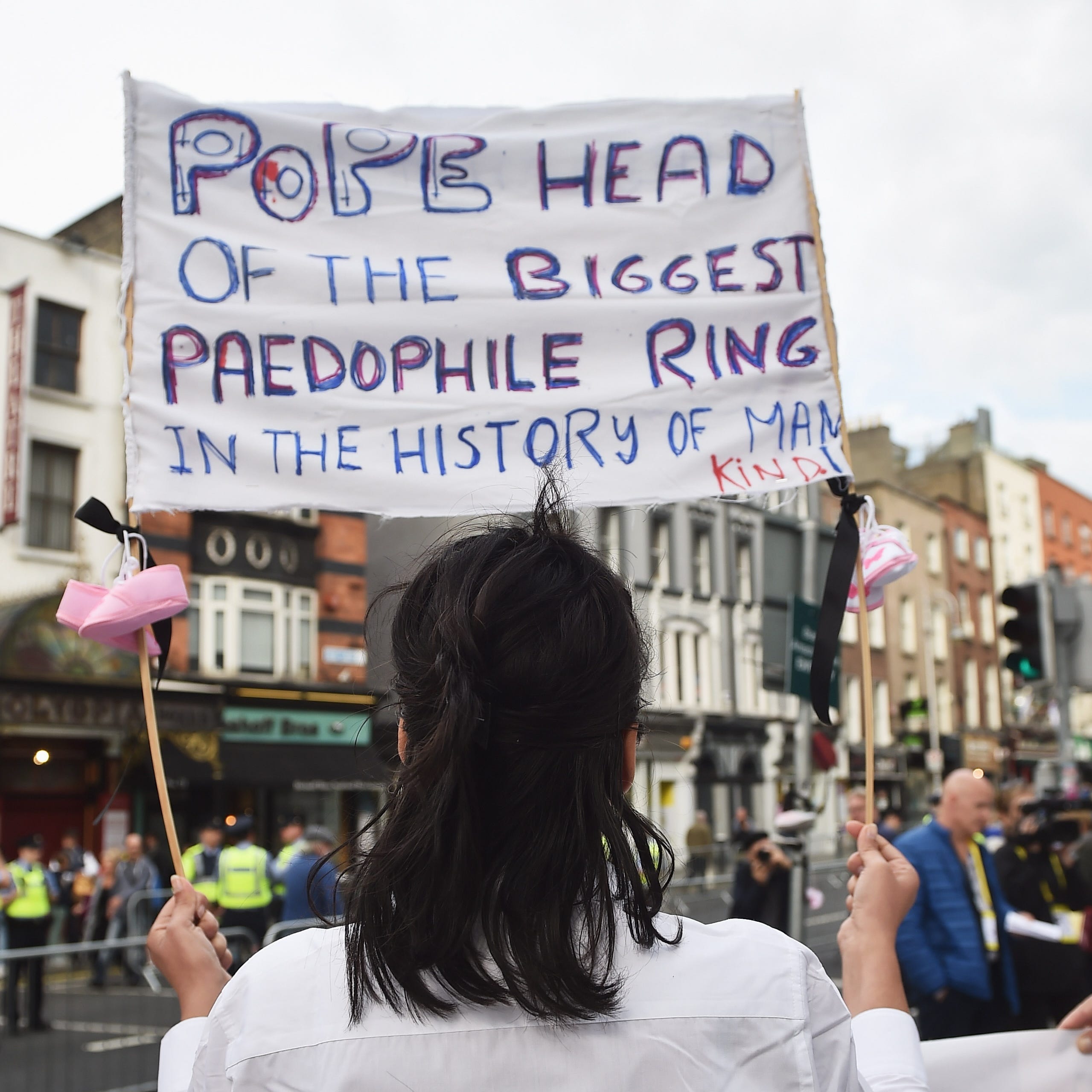 A protester holds up a sign in reference to the sex abuse scandal within the Catholic Church as Pope Francis travels through the city in the Popemobile on Aug. 25, 2018 in Dublin, Ireland.