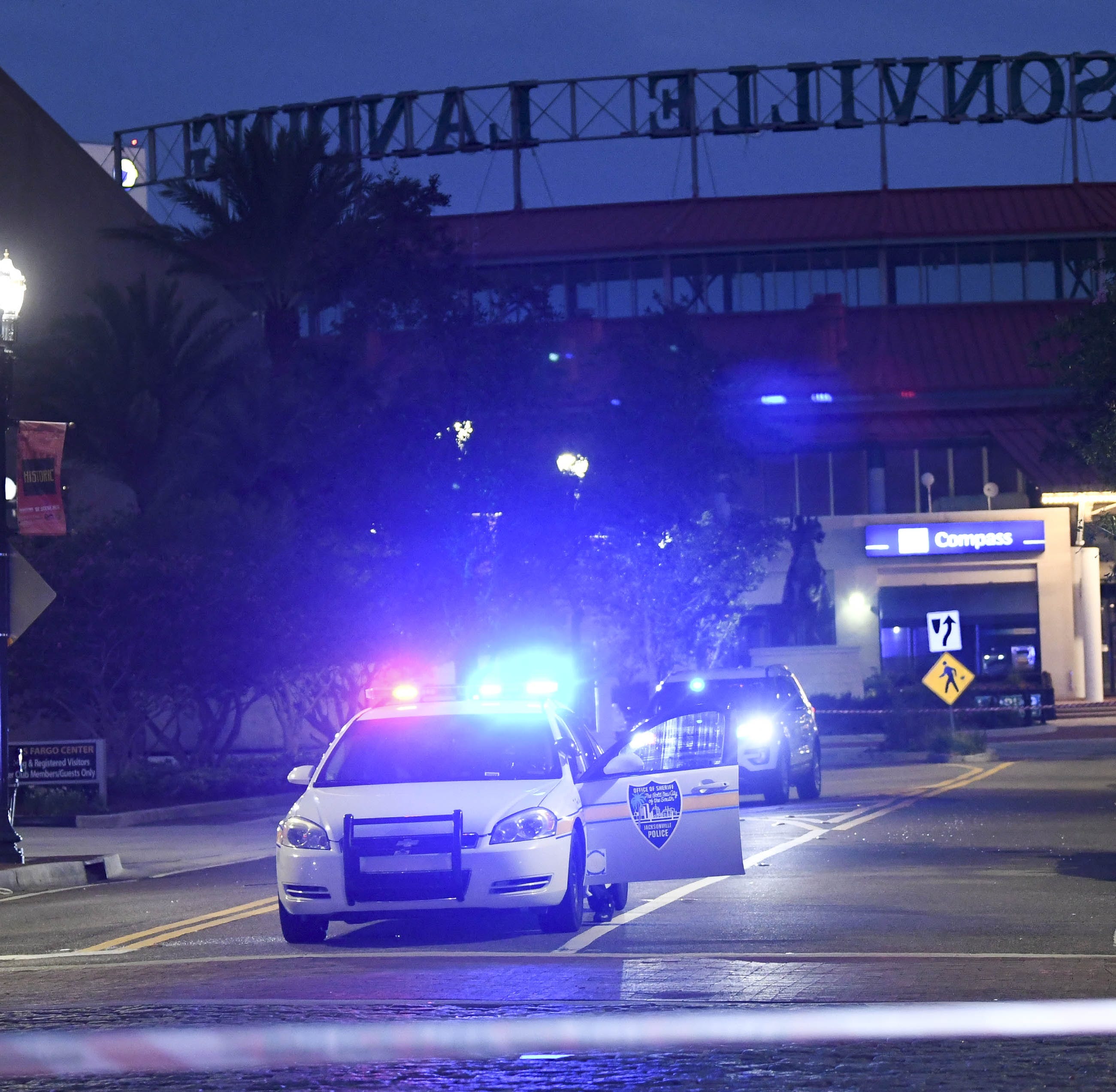 Police vehicles block the roads leading to Jacksonville Landing where four people were killed and several wounded at a Madden 19 tournament.