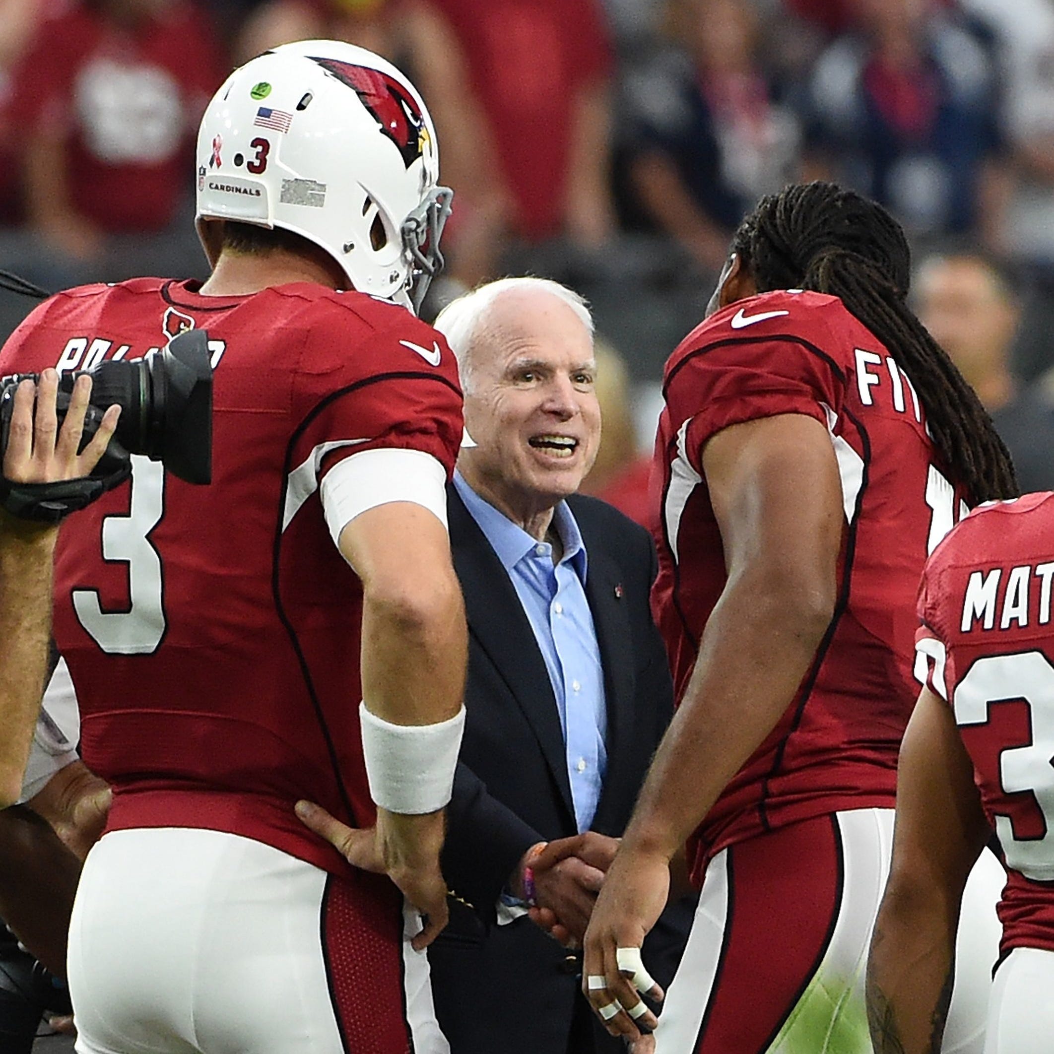 Cardinals wide receiver Larry Fitzgerald and former quarterback Carson Palmer shake hands with Sen. John McCain prior to a game on 2016.