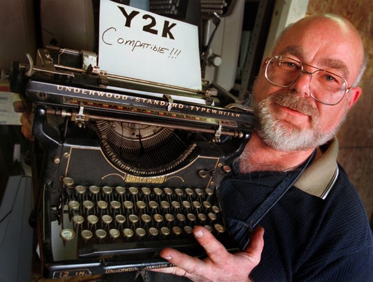 As the world prepared for its computer systems to melt down as we entered 2000, typewriter repairman, Terry Bordon holds a classic 1934 Underwood model 6, manual typewriter he jokingly placed a sign in the carriage that reads Y2K Compatible.  