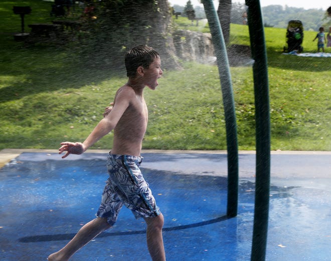 Jame Sandford of Wappingers Falls runs through the sprinklers at Bowdoin Park to cool down from the heat on August 28, 2018.