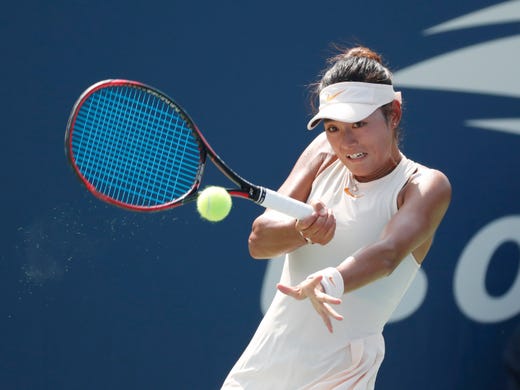 Yafan Wang of China returns a shot against Anna Karolina Schmiedlova.