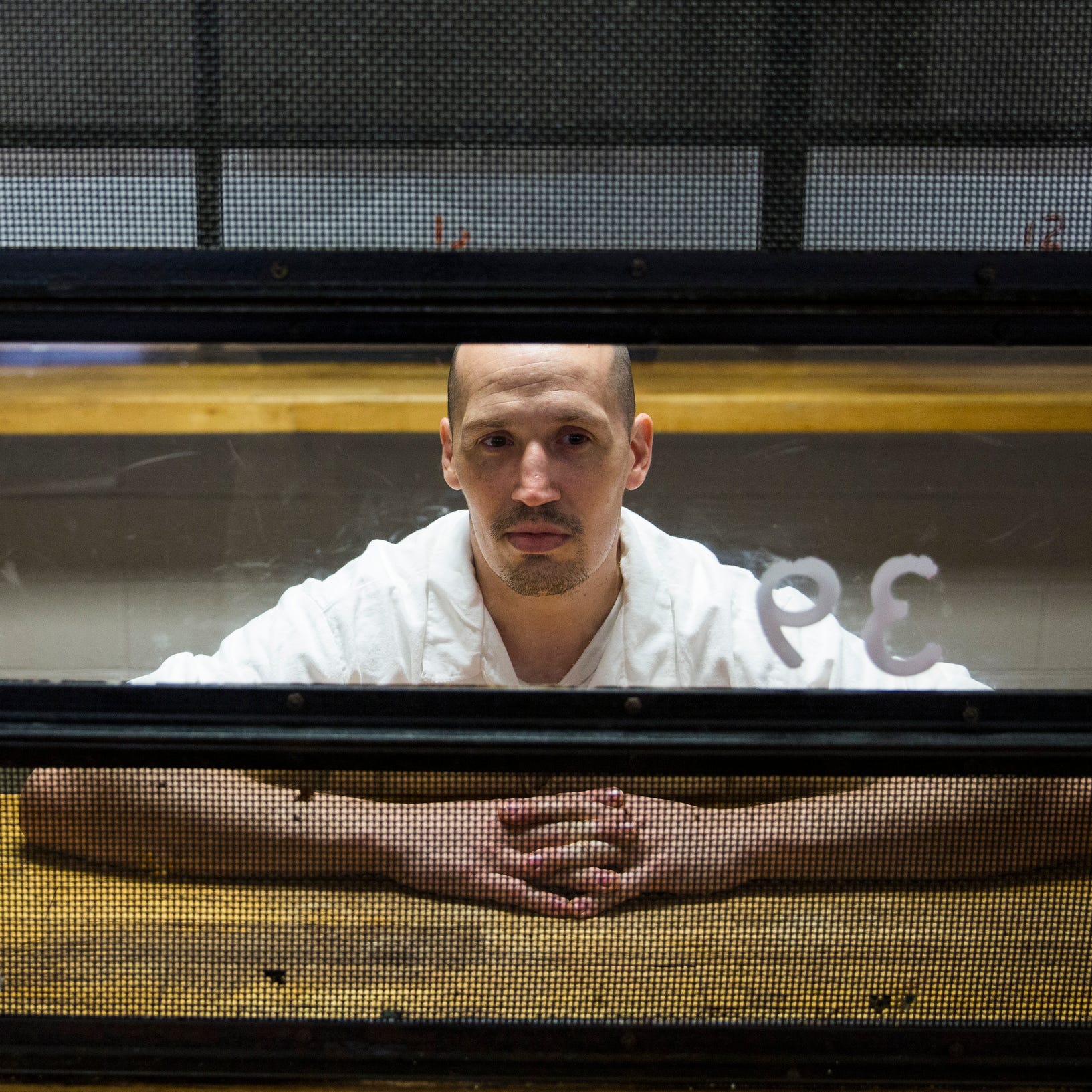David Randall White II speaks to a reporter from behind a glass wall at the George  Beto Unit maximum security prison in rural Tennessee Colony, Texas.