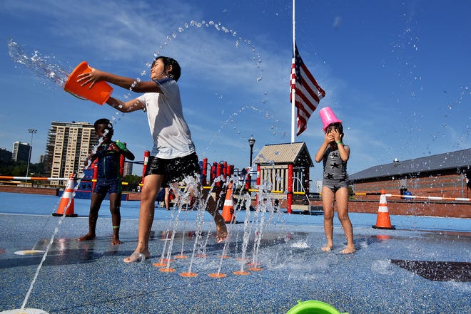 Children play at the sprinklers at Veterans Memorial field in Edgewater, NJ.