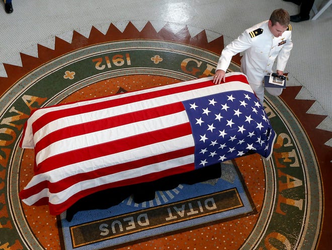 Jack McCain, son of Sen. John McCain, R-Ariz., touches the casket during a memorial service at the Arizona Capitol on Aug. 29, 2018, in Phoenix.