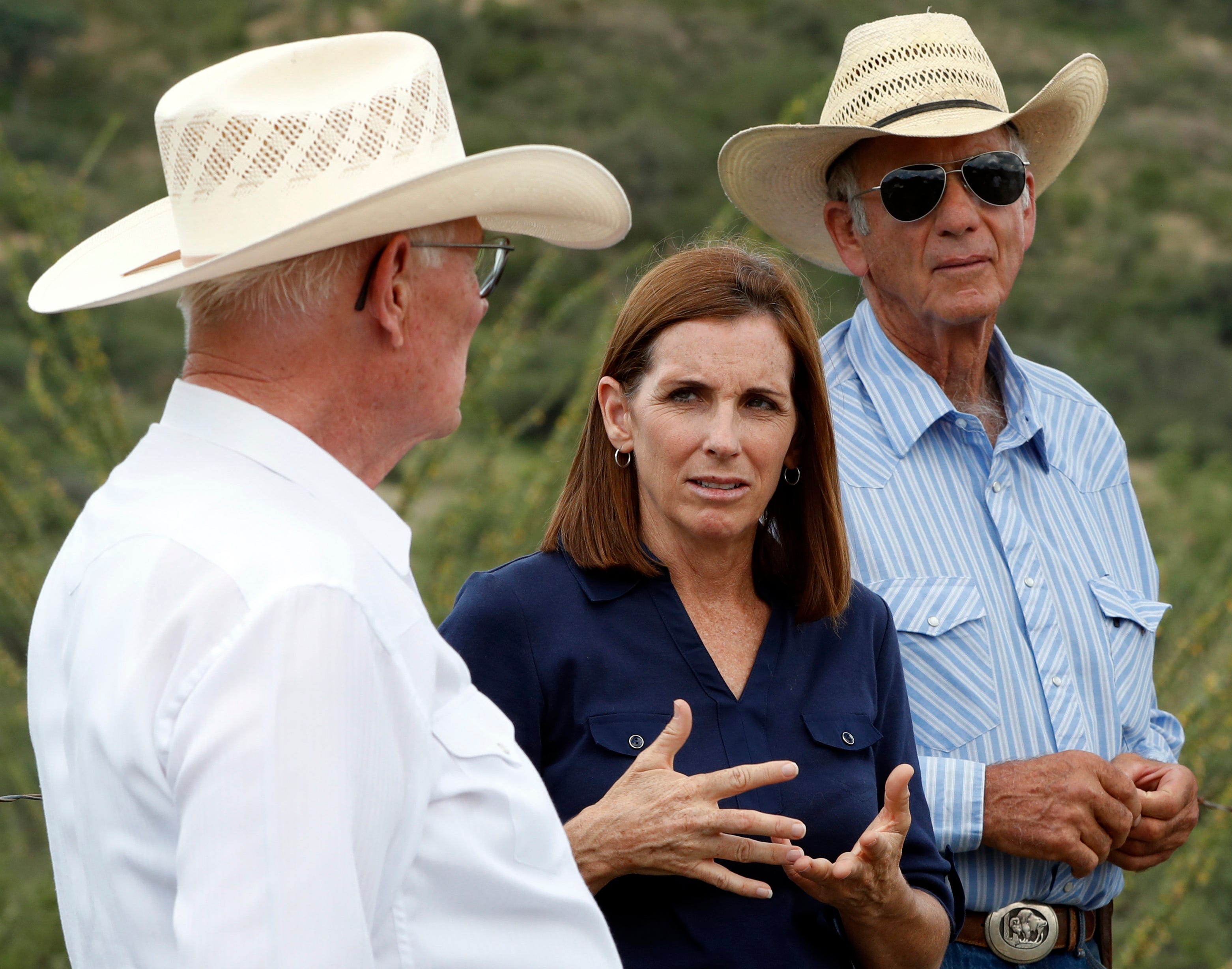 In this Wednesday, Aug. 22, 2018, Rep. Martha McSally, R-Ariz., stands at the international border with Mexico, with ranchers Jim Chilton, left, and Tom Kay, right, south of Arivaca, Ariz. McSally won the GOP nomination for Senate Tuesday.