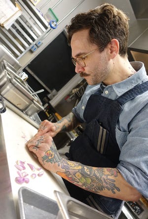 Jeff Kraus of Crepe Bar prepares a dish with i'itoi onions.