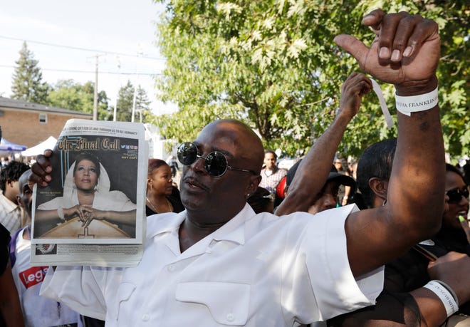 Roger Chambers holds up an issue of "The Final Call," featuring a photograph of Aretha Franklin outside Greater Grace Temple Friday morning.