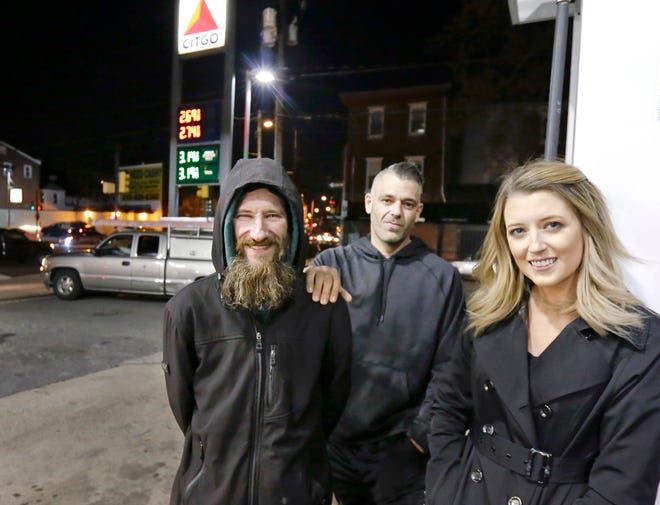 In this Nov. 17, 2017, file photo, Johnny Bobbitt Jr., left, Kate McClure, right, and McClure's boyfriend Mark D'Amico pose at a Citgo station in Philadelphia.