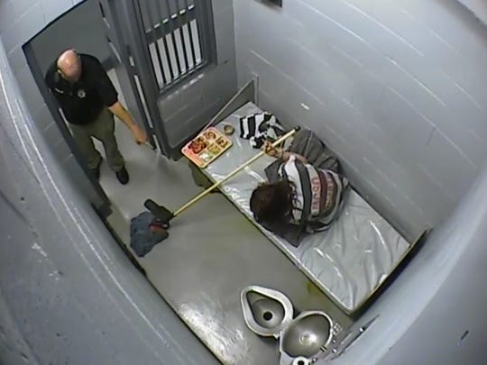 This still taken from Mineral County Sheriff's Office surveillance video shows Sgt. Jim Holland asks Kelly Coltrain to mop her cell.