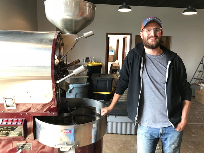 Coffea CEO Bryan Kegley poses with the company's roaster, which moved this week to a new location attached to the Louise Avenue shop.
