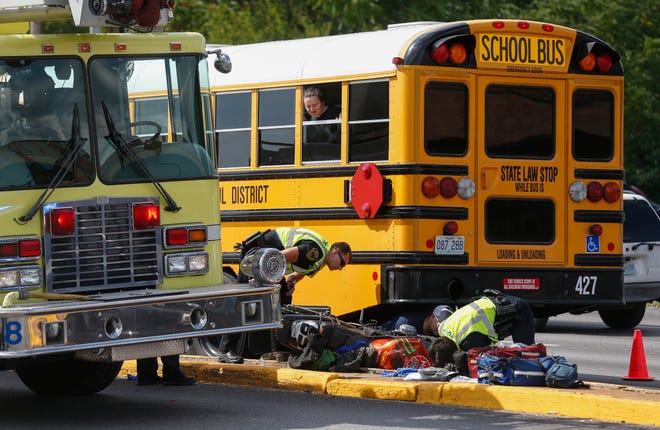 Police and emergency personnel work the scene of an accident at Chestnut Expressway and Grant Avenue involving a school bus and a motorcycle on Friday, Aug. 31, 2018.