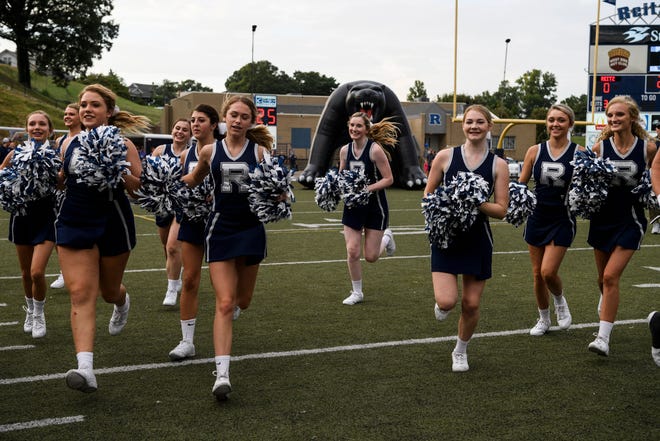 The Reitz Panthers cheerleaders rush the field before the football team takes on the Castle Knights at the Reitz Bowl in Evansville, Ind., Friday, Aug. 31, 2018.