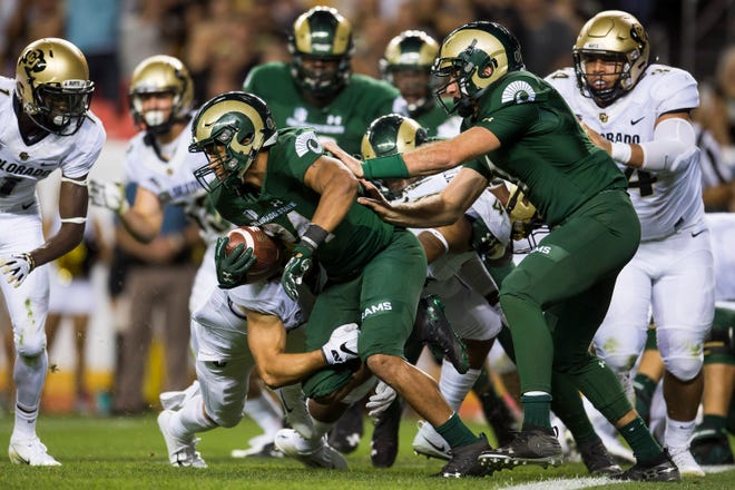 Colorado State University senior running back Izzy Matthews (24) escapes a safety against the University of Colorado defenders on Friday, Aug. 31, 2018, at Broncos Stadium in Denver, Colo. 