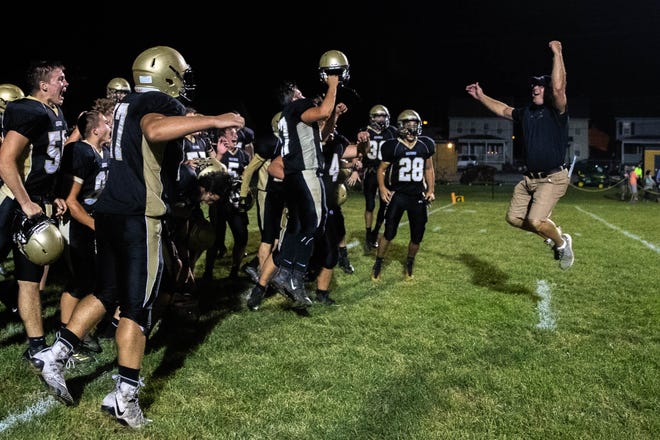 Delone Catholic defensive coordinator Dave Staub leaps into the air with his team after winning a game against York Suburban, Friday, Aug. 31, 2018, at Delone Catholic High School in McSherrystown. Delone beat York Suburban 62-0.