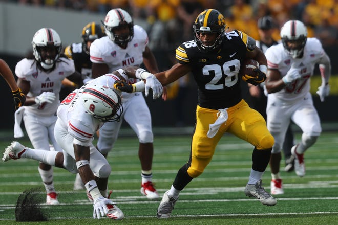 Iowa's Toren Young pushes away Northern Illinois' Mykelti Williams as he runs down field during their game at Kinnick Stadium on Satuday, Sept. 1, 2018.