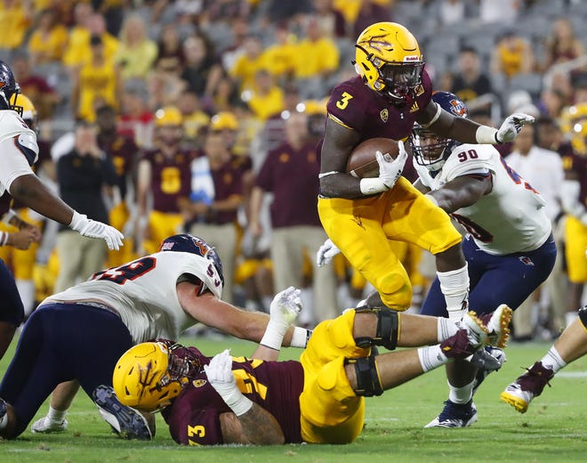 Arizona State Sun Devils running back Eno Benjamin (3) leaps over teammate Arizona State Sun Devils offensive lineman Cohl Cabral (73) against UTSA during the second half at Sun Devil Stadium in Tempe, Ariz. on Sept. 1, 2018.