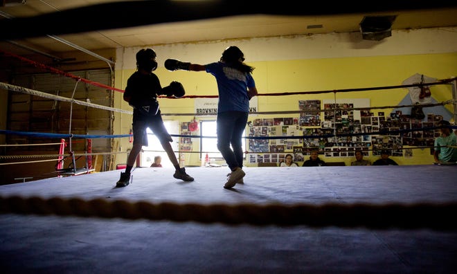 ADVANCE FOR USE WEDNESDAY, SEPT. 5, 2018 AND THEREAFTER-Beatrice Kipp, 13, right, spars with Timmy Sellars, 14, at the Blackfeet Native Boxing Club on the Blackfeet Indian Reservation in Browning, Mont., Saturday, July 14, 2018. "I'm protective of our children because of human trafficking. What happened to Ashley is really worrying," said Frank Kipp who teaches his daughters how to box and runs the club. "We teach our girls if someone grabs you, you fight to your death." (AP Photo/David Goldman)