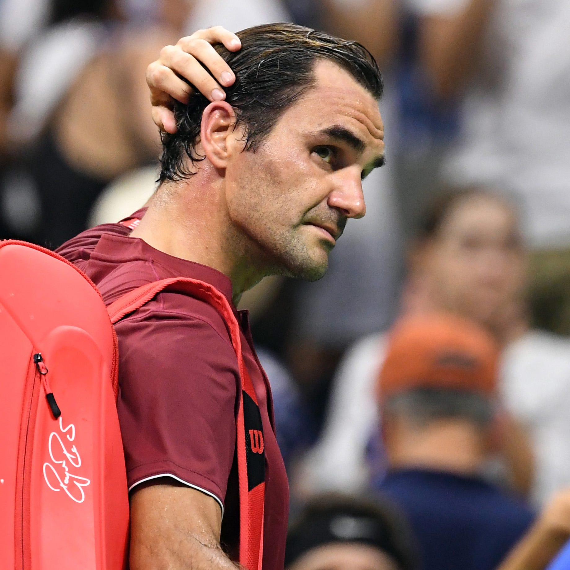 Roger Federer owalks off the court after his loss to John Millman.