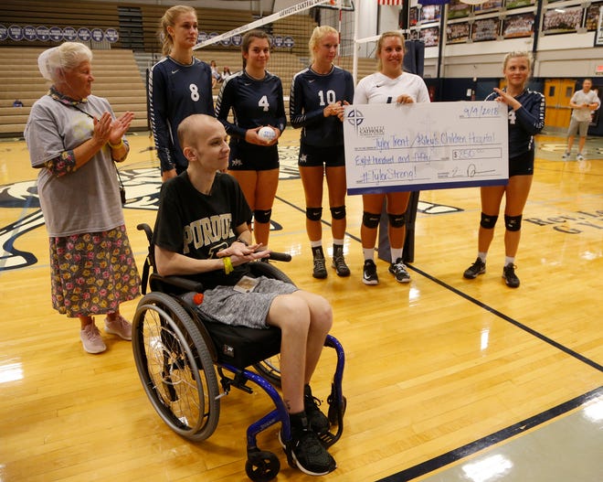 Central Catholic players present Tyler Trent with a check to benefit Riley Children’s Hospital before meeting Lafayette Jeff to Spike Out Cancer Tuesday, September 4, 2018, in Lafayette. Trent is a sophomore at Purdue battling cancer. CC defeated Jeff 25-14, 25-17, 25-13.