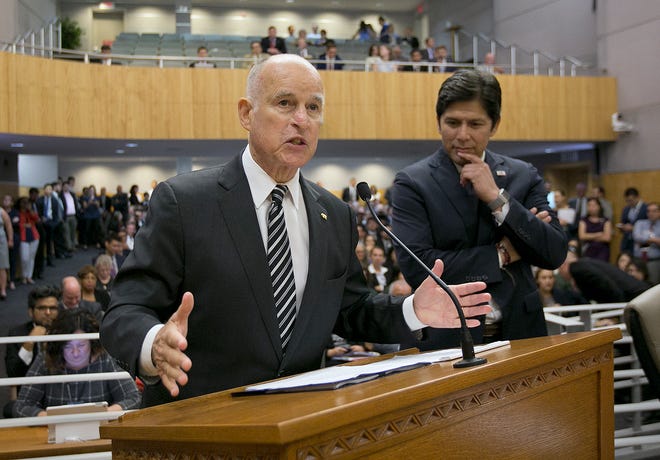 In this July 13, 2017 file photo, Gov. Jerry Brown, left, flanked by Kevin de León, urges members of the California Senate's Environmental Quality Committee to approve a pair of bills to extend the state's cap-and-trade program.