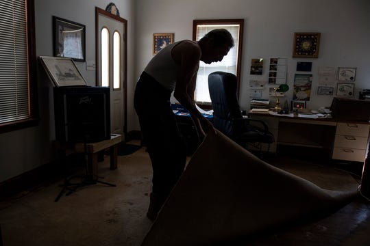 Gary Andrews pulls up a piece of carpet to show the water damage underneath following Friday's flash floods. Andrews, 66, who suffers from physical problems and was diagnosed with lymphatic cancer a month ago, doesn't know how he'll get everything fixed around his home. 'I know I can't do it by myself,' he said.