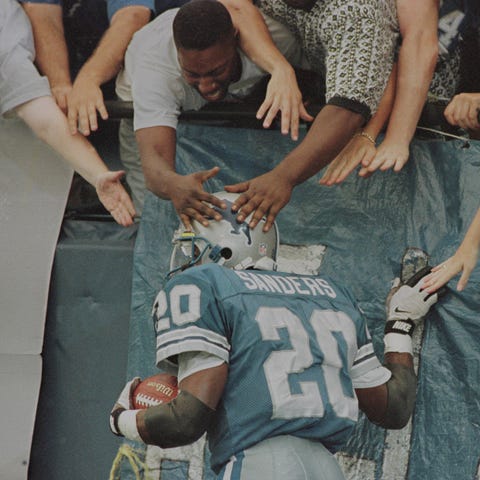 Barry Sanders celebrates with fans after a...