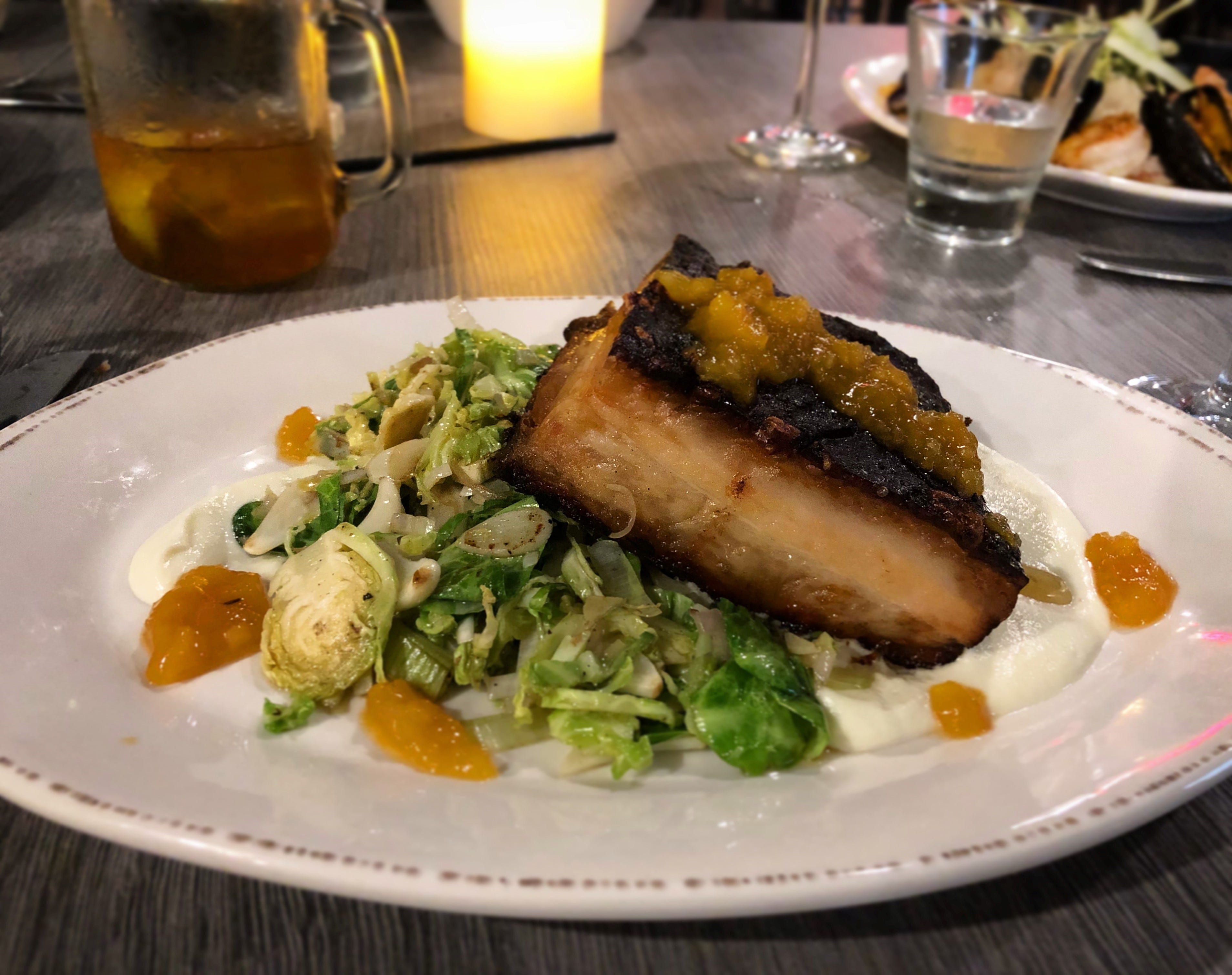 The Jac smokes its pork belly, then finishes it in a pan. The dish is served with shaved Brussels sprouts, a parsnip and cauliflower puree, and apricot gastrique.