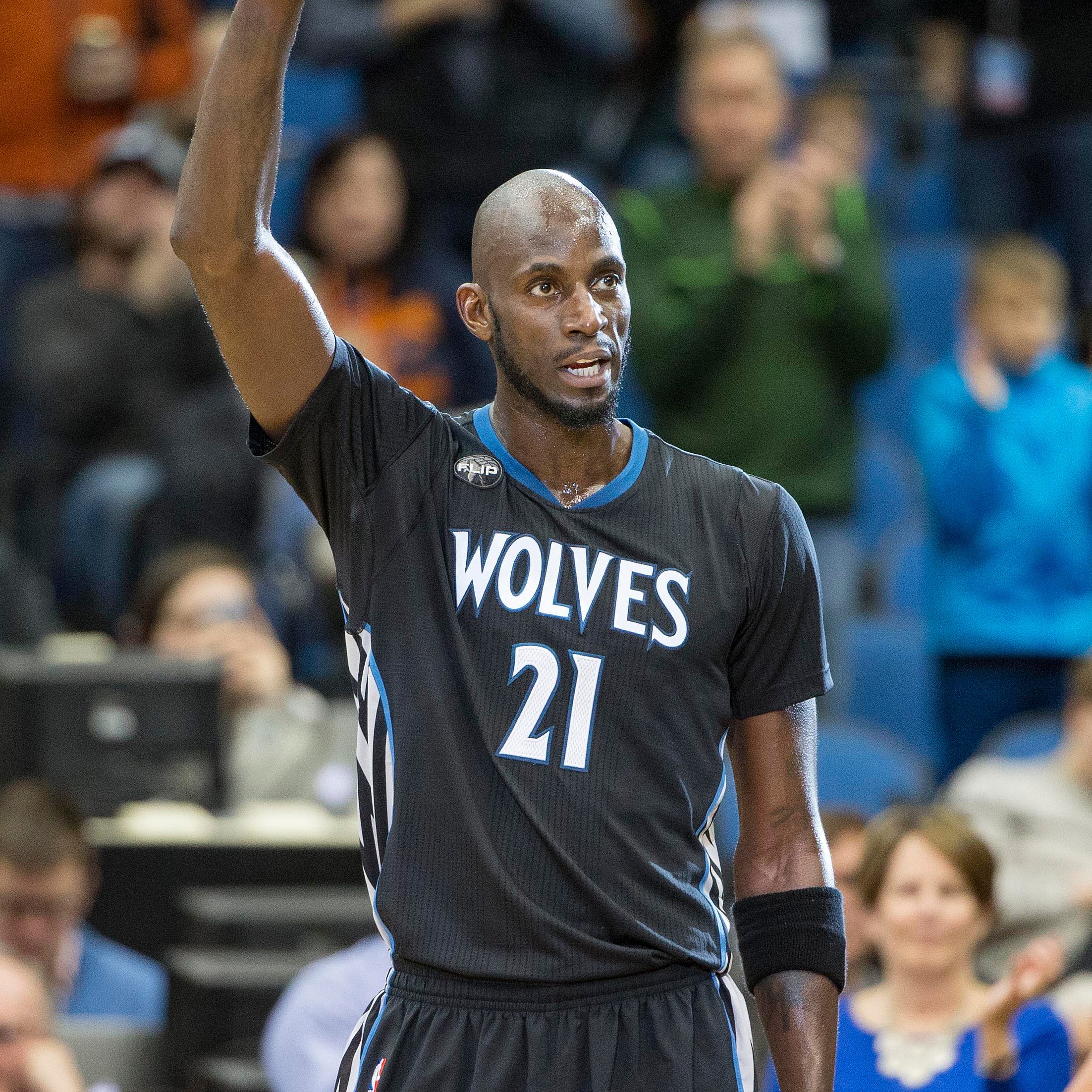 Minnesota Timberwolves forward Kevin Garnett waves to fans during a stoppage in play.