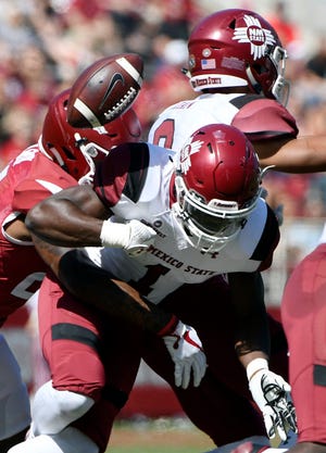 In this Sept. 30, 2017, file photo, New Mexico State kick returner Jason Huntley fumbles the ball as he is hit by Arkansas defender Micahh Smith on a kickoff return in the second half of an NCAA college football game in Fayetteville, Ark. For the first years under coach Bob Davie, the Lobos averaged 14 turnovers a season, among the best in the country. Last year, New Mexico committed 29.