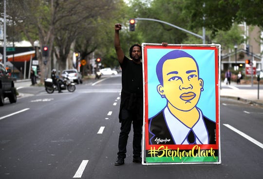 A protester from Black Lives Matter is holding an illustration of Stephon Clark during a march and demonstration on the streets of Sacramento on April 4, 2018 in Sacramento, California.