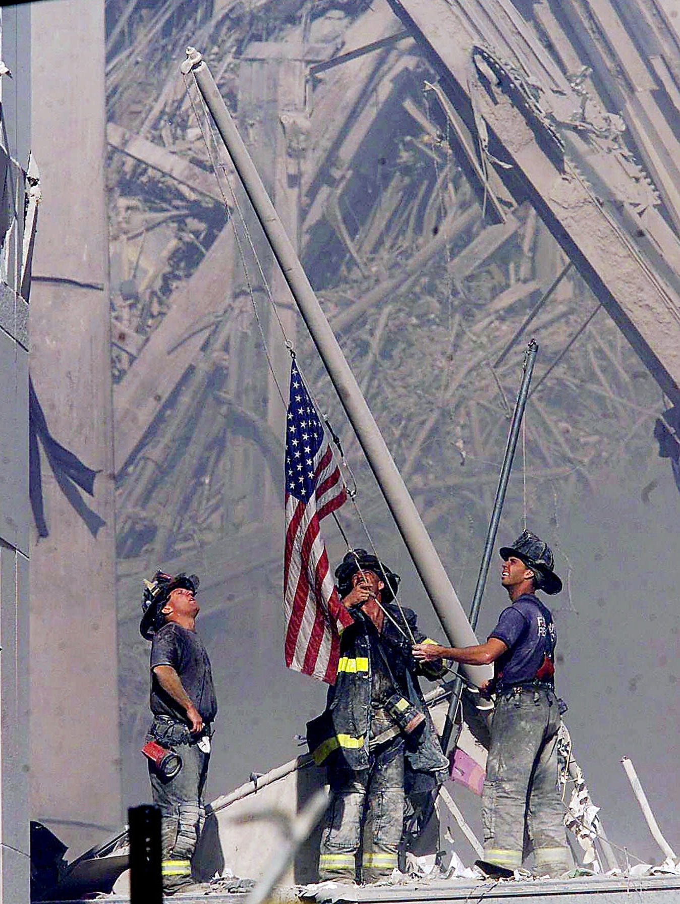 Firefighters raise a flag at the World Trade Center in New York.