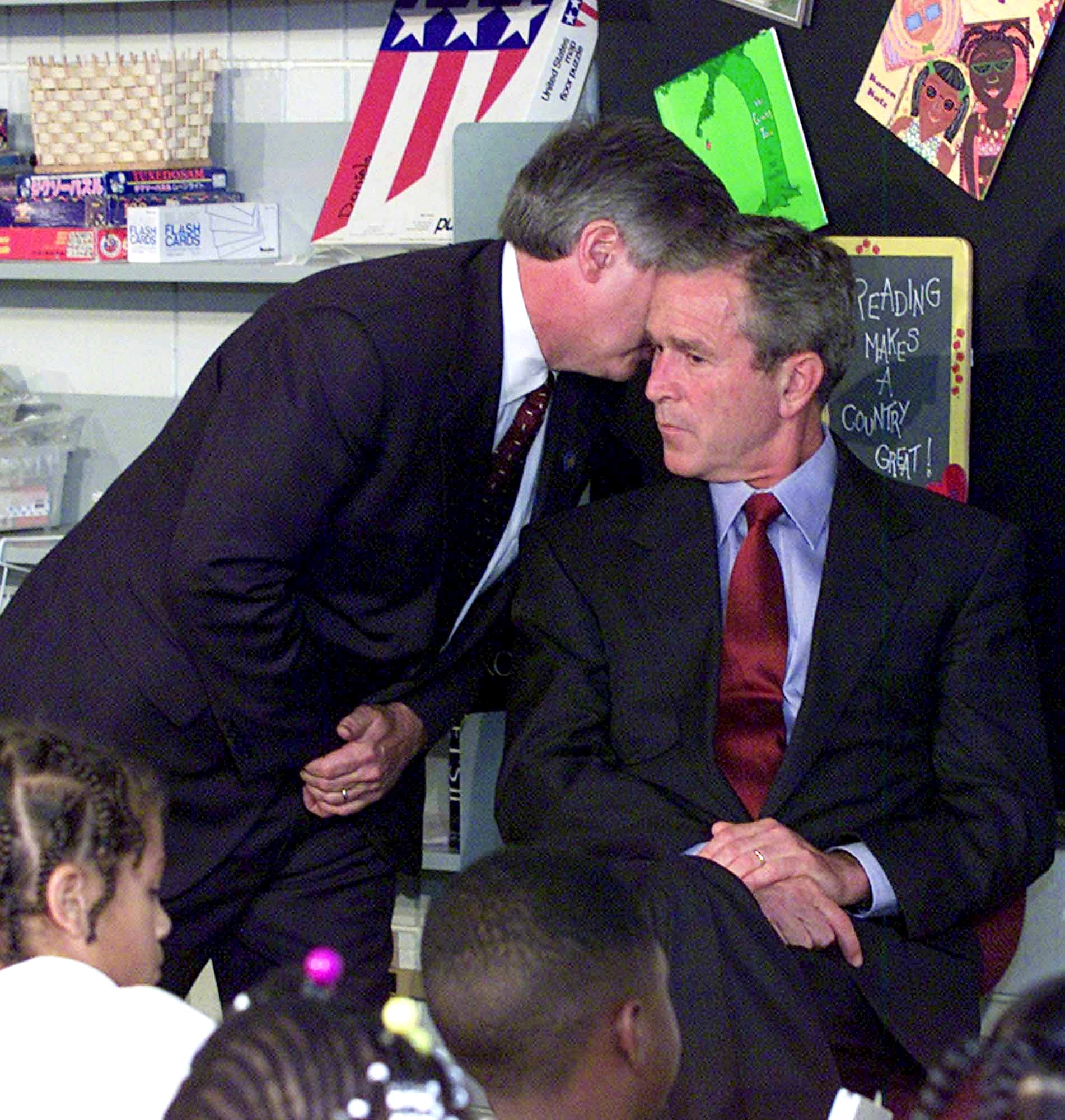 President George W. Bush's Chief of Staff Andy Card whispers into the ear of the president, giving him word of the plane crashes into the World Trade Center, during a visit to the Emma E. Booker Elementary School in Sarasota, Fla.