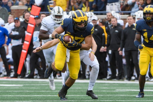 Michigan running back Joe Hewlett recovers a loose ball after a blocked punt attempt by Western Michigan in the second quarter.