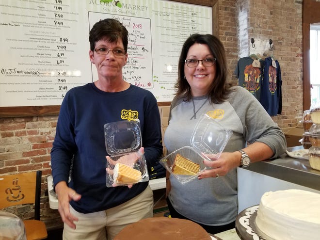 Tina Lee (left) and Christine Braugler, owner of Acorn Market in Salisbury, Maryland, show off Smith Island cakes they are selling at the National Folk Festival on Sept. 8, 2018.