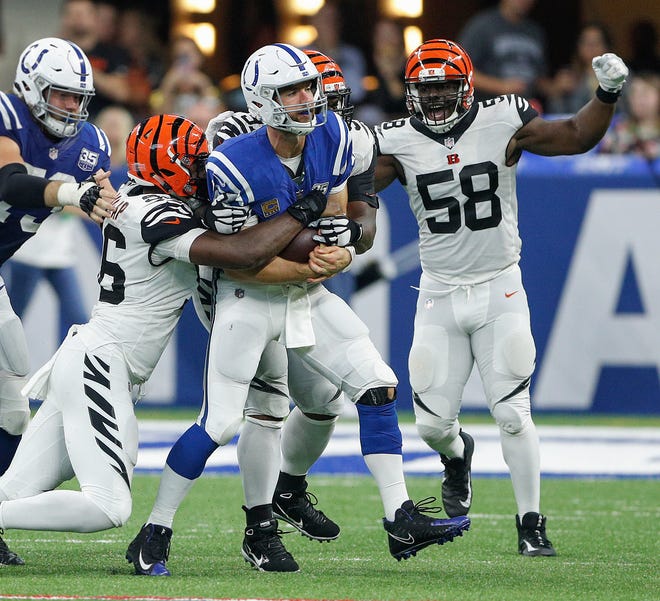 Indianapolis Colts quarterback Andrew Luck (12) is sacked by Cincinnati Bengals defensive end Carlos Dunlap (96) and  defensive end Al-Quadin Muhammad (97) in the second half of their game at Lucas Oil Stadium on Sept. 9, 2018. The Indianapolis Colts lost to the Cincinnati Bengals 34-23.