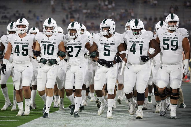 TEMPE, AZ - SEPTEMBER 08:  The Michigan State Spartans walk arm in arm onto the field before the college football game against the Arizona State Sun Devils at Sun Devil Stadium on September 8, 2018 in Tempe, Arizona.  (Photo by Christian Petersen/Getty Images)