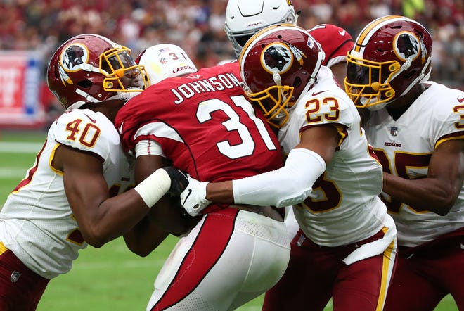 Arizona Cardinals runnong back David Johnson is stopped by the Washington Redskins in the first half at State Farm Stadium.