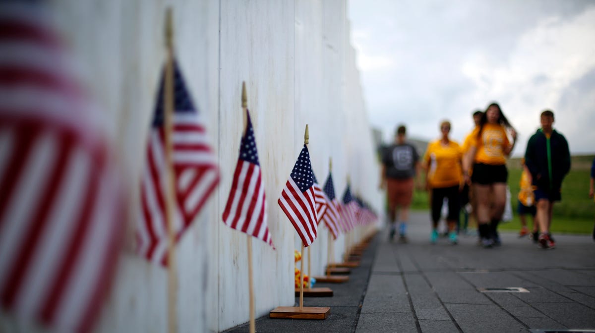 Visitors to the Flight 93 National Memorial pause at the Wall of Names containing the names of the 40 passengers and crew of United Flight 93 that were killed in this field in Shanksville, Pa., on May 31, 2018.