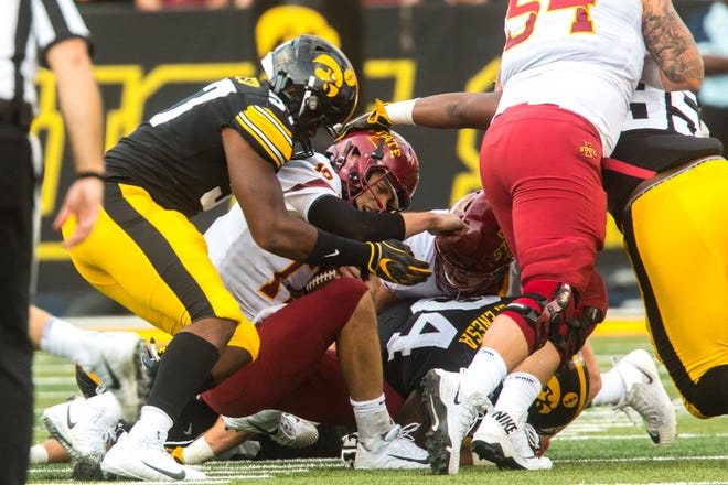 Iowa State quarterback Kyle Kempt (17) gets sacked by Iowa defensive end Chauncey Golston (57) and defensive end A.J. Epenesa (94) during the Cy-Hawk NCAA football game on Saturday, Sept. 8, 2018, at Kinnick Stadium in Iowa City.
