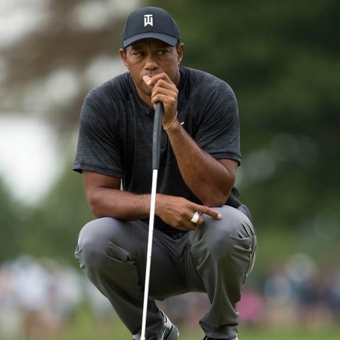 Tiger Woods looks on as he waits to putt on the...