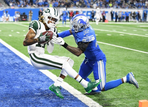 Jets' Robby Anderson (11) holds on to the ball to score a touchdown despite the efforts of Lions defensive back Tavon Wilson in the first quarter.